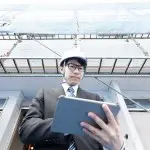建築現場でタブレットを確認する男性の写真
