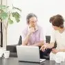 パソコンを見ながら話す老夫婦