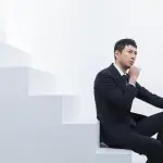 階段に腰掛ける男性の写真