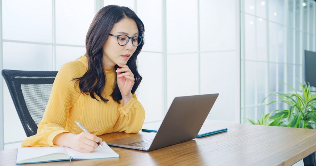 ノートパソコンで家の査定を調べている女性